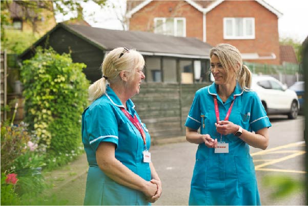 Hospice at home nurses talking on a residential street