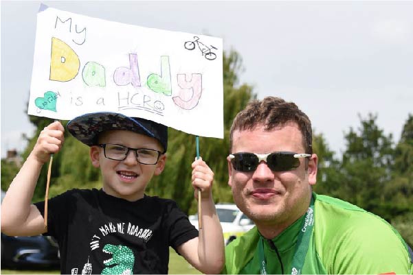 Michael with his son holding a sign saying my dad is a hero
