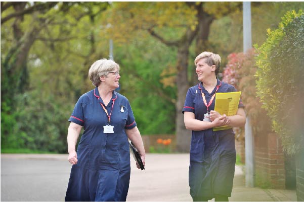 Two hospice nurses walking down the street